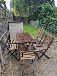 a picnic table and two chairs next to a fence at LEB Homes UK, 3 Bedroom House - 2 mins walk to station in Crawley