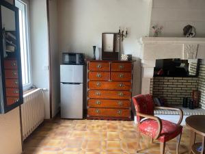 a kitchen with a refrigerator and a table and a chair at La Durellerie in Coulongé