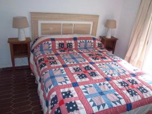 ein Bett mit einer rot-weiß-blauen Steppdecke darauf in der Unterkunft Apartamento rural Casa Medico in Turre + 55 Fotos