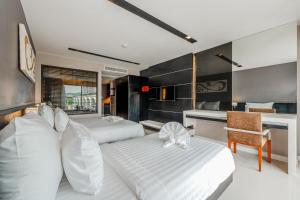 una camera con 2 letti bianchi e una scrivania di C197 Condo 1BR with Pool 3 Min Walk to Beach a Patong Beach