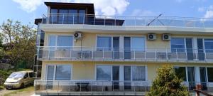 un grande edificio giallo con un balcone e un'auto di Къща за гости ,,Лозница ГТ'' a Varna
