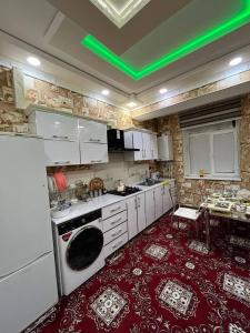 a kitchen with white appliances and a red floor at RaniyaHouse in Urganch