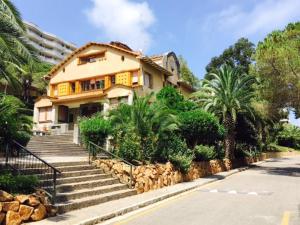 a house with stairs in front of a street at Cosy apartment with fabulous SEA VIEWS 70's style in Sant Feliu de Guixols