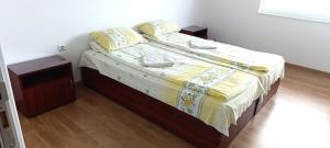 a bedroom with a bed with a yellow and white blanket at Къща за гости ,,Лозница ГТ'' in Varna City