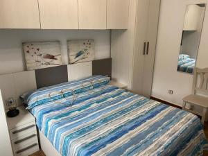 a bedroom with a bed with a blue and white comforter at Cabaña de ensueño en el bosque y junto al mar in Miengo