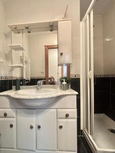 a bathroom with a sink and a large mirror at Vistas al mar, a 1 min de la playa, terraza, wifi in Laredo