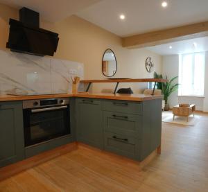 a kitchen with green cabinets and a mirror at La Bulle Chic, Netflix - central in Montargis