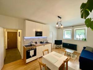 a kitchen and living room with a table and chairs at Cozy Self check-in Apartment in vibrant Ruzinov area, Komárnická 42, Bratislava in Bratislava +13 photos