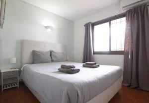 ein Schlafzimmer mit einem Bett, auf dem zwei Handtücher liegen in der Unterkunft Ground floor near the beach in Málaga + 14 Fotos