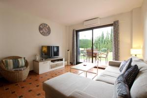 ein Wohnzimmer mit Sofa und Fernseher in der Unterkunft Ground floor near the beach in Málaga