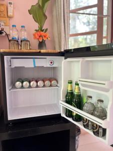 an open refrigerator filled with lots of soda bottles at Khaosok gallery & camp in Ban Khong Hua Kwang +80 photos