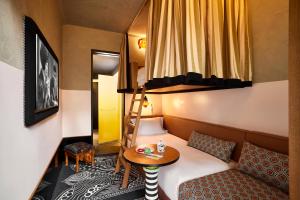 une petite pièce avec un lit et une table dans l'établissement Mama Shelter Singapore Orchard, à Singapour 51 autres photos