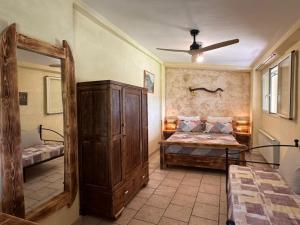 a bedroom with a bed and a large wooden cabinet at Gufo in Pitigliano