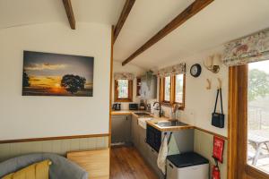 two views of a kitchen in a tiny house at Fotheringhay Glamping in Fotheringhay