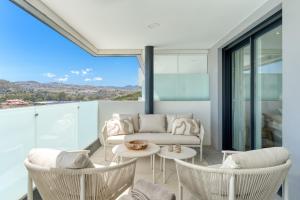 Una sala de estar con un sofá y sillas y una mesa. en Casa Cala Serena, en Mijas