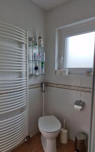 a white bathroom with a toilet and a window at Haus Bernd in Geldern +18 photos