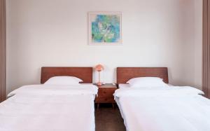 two beds sitting next to each other in a bedroom at Tianmen Mountain Panorama & Cultural Art Exchange Hostel in Zhangjiajie