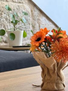 un jarrón lleno de flores naranjas en una mesa en CENTRO VIGO Apartamento reformado, AVE-VIALIA - muy céntrico 5PAX, en Vigo