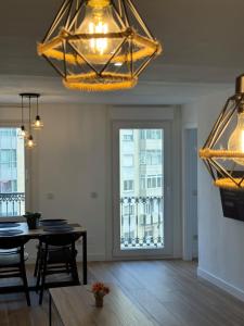 Un comedor con una mesa y un gran ventanal. en CENTRO VIGO Apartamento reformado, AVE-VIALIA - muy céntrico 5PAX, en Vigo