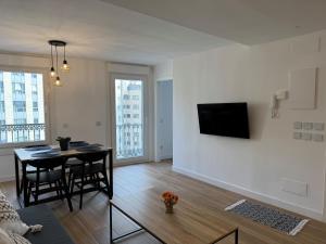 a living room with a table and a tv on a wall at CENTRO VIGO Apartamento reformado, AVE-VIALIA - muy céntrico 5PAX in Vigo