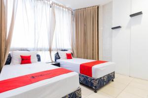 泗水RedDoorz at Sparkling Hotel Surabaya的有窗户的房间里有两张床