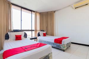 泗水RedDoorz at Sparkling Hotel Surabaya的有两张床和一扇窗户的酒店房间