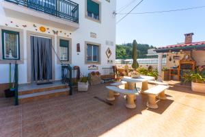 a patio with benches in front of a building at Moradia Valdemar in Nazaré