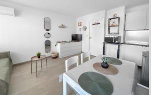 a living room with a table and a kitchen at Studio cosy clim - Piscine - Plage à pied - Cap d'Agde in Cap d'Agde