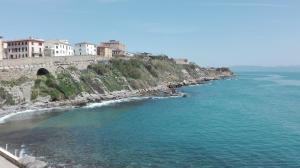 a body of water with buildings on top of a mountain at Albergo Italia in Piombino