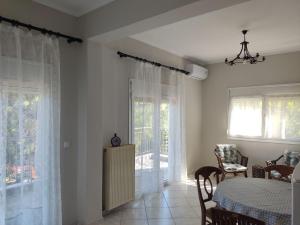 a dining room with a table and some windows at Country treasure in Nea Michaniona