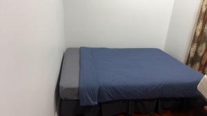 Cama en habitación con manta azul en 3 Bedroom House, 12 Phyllis St, Mt Albert, Auckland, en Auckland 1 foto más