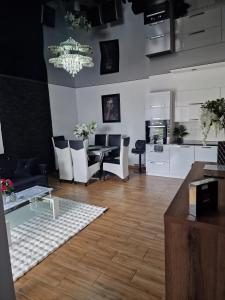 a living room with a dining table and a kitchen at Apartament Marzenie in Siechnice