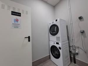 a washer and dryer in a room with a wall at Medea Suites Apartamentos in Mérida