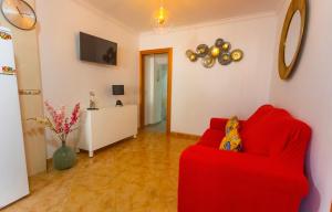 a living room with a red couch and a table at Moradia Valdemar in Nazaré