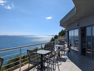a balcony with tables and chairs overlooking the water at Ark Beach Apartments in Split