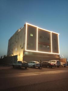 a large building with cars parked in front of it at شقق فاخره مفروشه القادسيه الثاني in Tabuk +13 photos