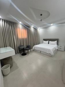 a bedroom with a bed and a desk and a window at شقق فاخره مفروشه القادسيه الثاني in Tabuk