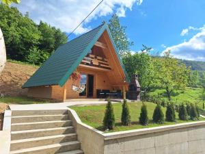 a small wooden cabin with a green roof at Vasin konak in Vlasenica