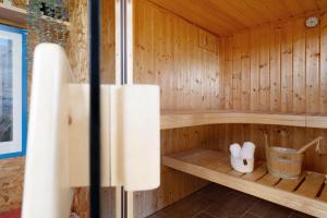 a wooden sauna with two white shoes in it at Ferienhaus Brasch in Grömitz