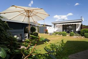 an umbrella in the yard of a house at Ferienhaus Brasch in Grömitz