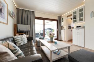 a living room with a couch and a table at Ferienhaus Brasch in Grömitz +30 photos