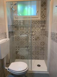 a bathroom with a toilet and a glass shower at Appartamento Oberdan in Milano Marittima