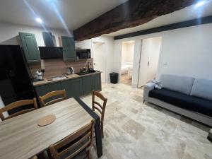 a kitchen and living room with a table and a couch at Gîtes, Les Fontaines de Normandie in Saint-Julien-sur-Calonne +14 photos