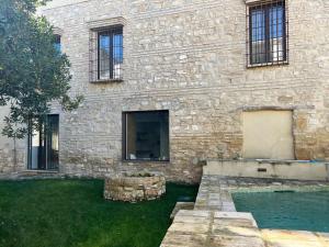 ein Steingebäude mit einem Swimmingpool davor in der Unterkunft Casa con jardín y piscina en Córdoba in Córdoba