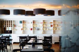 ein Esszimmer mit Tischen, Stühlen und Regalen in der Unterkunft St Moritz Hotel Houses in Polzeath