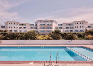 ein Pool mit Gebäuden im Hintergrund in der Unterkunft St Moritz Hotel Houses in Polzeath + 144 Fotos