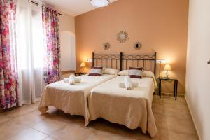 ein Schlafzimmer mit zwei Betten und einem großen Fenster in der Unterkunft Apartamentos Rurales Tía María in Mata de Alcántara
