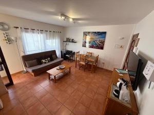 a living room with a couch and a table at Apartamento Brisas del Sur - Oasis Tenerife Sur in Playa de San Juan