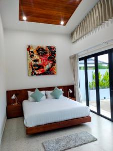 a bedroom with a bed and a painting on the wall at Rawai Villa in Rawai Beach +21 photos