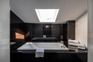 La salle de bains est pourvue d'une baignoire et d'une lucarne. dans l'établissement Hôtel Le Canberra, à Cannes